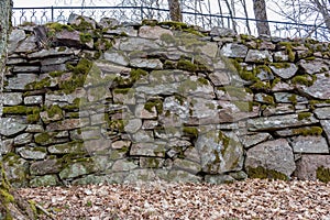 An old manmade stone wall with moss on it