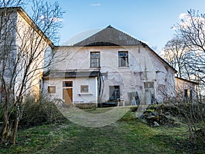 Old manor house surrounded by trees, partially inhabited