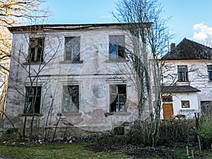 Old manor house surrounded by trees, partially inhabited