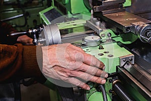 Old mans hand on an old lathe machine