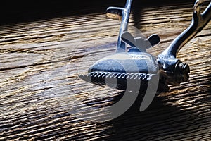 Old manual haircut machine on old wooden scrached background.