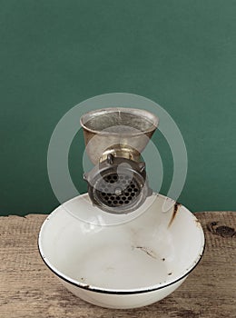 Old manual meat grinder and a white enamel bowl