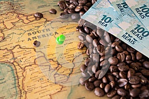 Old map of Brazil with scattered coffee beans and 100 reais banknotes, Concept of the largest coffee producer and exporter in the