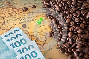 Old map of Brazil with scattered coffee beans and 100 reais banknotes, Concept of the largest coffee producer and exporter in the