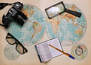 Old map of the hemispheres on it a camera, clock, magnifier and a notebook