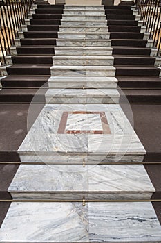 Old marble stairs with brown carpet