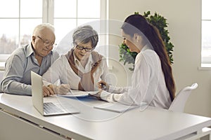 Old married family couple signing contract agreement at bank manager meeting