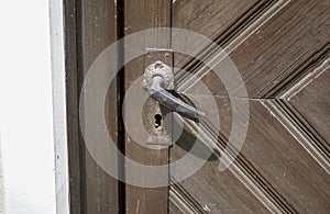 Old massive door with decorative door handle and lock, all still functional