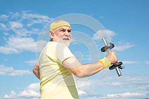 Old mature man exercising with dumbbell. Senior sportsman in sport center. Health club or rehabilitation center for