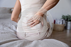 Old mature woman sit on bed touch back feel backpain photo