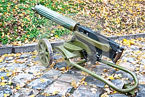 An old Maxim machine gun against a background of stone pavers. Military scenery