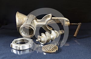 An old meat grinder on a glass table with a reflection