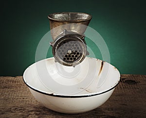 Old meat grinder and a white enamel bowl