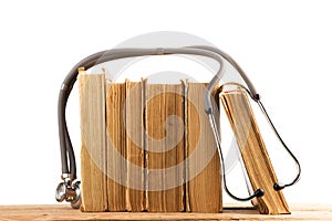 Old medical books with stethoscope, medicinal herbs isolated on