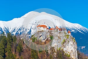 Old medieval castle on the rock against the snowy mountains