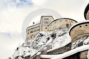 Old medieval european unassailable fortress or castle on hill at alpine austrian Kufstein city covered with big snow photo