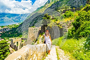 Old Medieval fortifications ruins and hiking woman on ladder Montenegro