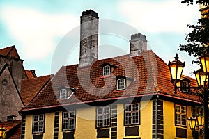 Old medieval house in street latern lamp lights in the historic center of Riga at sunset