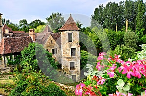 Medieval house and tower with flowers in Carennac, France