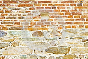 Old medieval italian stone and brick wall, built with splitted blocks, recently restored