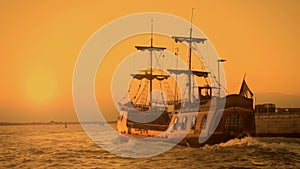 Old medieval ship gracefully sailing to open sea, travelling towards adventures