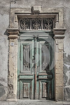 Old Medittaranean door in Cyprus with peeling paint but remnants of grandeur