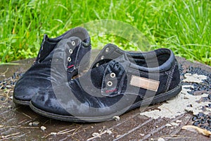 Old men`s shoes. Abandoned on the street after a rain. Worn and