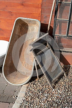 Old metal bathtub based on a wooden wall. Accessories for person