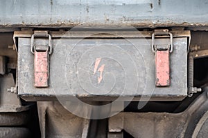 Old metal box with a sign of electric voltage on an electric locomotive, close up