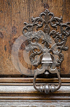 Old metal carved handle on a wooden front door