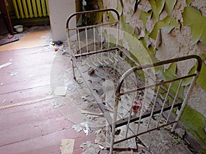 An old metal children`s bed in an abandoned kindergarten in Chernobyl