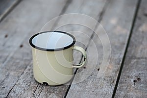 Old metal cup on wooden table