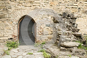 Old metal door at an ancient stone wall