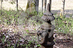 old metal fence post with forgings on it on grass background