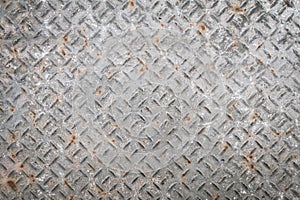 Old metal floor plate with diamond pattern and rusty background