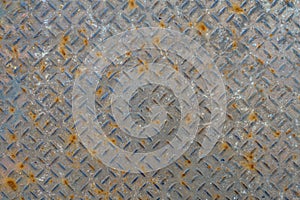 Old metal floor plate with diamond pattern and rusty background