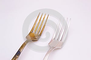 Old metal forks on a white background.