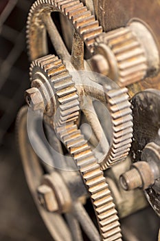 Old metal gears interlocking on the outside of a piece of machinery