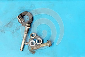 Old metal key and nut on blue background with copy space for text.