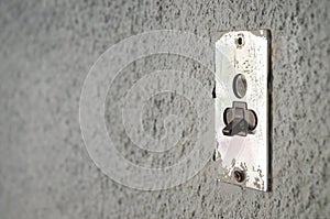 Old metal lighting electrical switch on grey wall