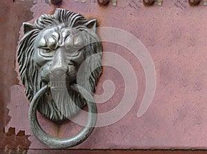 old metal lion knock door on grunge red wall background.