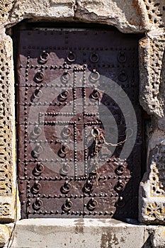 Old metal medieval door with a chain at the entrance to the Trinity Church in Gergeti, Georgia