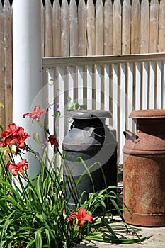 Old metal milk jugs on wood stoop