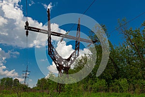 Old metal power line tower on cloudy sky background