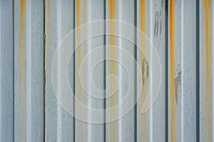 An old metal rippled wall with rusty streams. Abstract background.