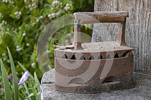 Old metal rusty vintage iron on coals.The old device for Ironing clothes.