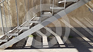 Old metal staircase with lattice steps and geometric striped shadows underneath