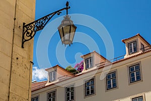 The old, metal, street lamps mounted on colorful tiled buildings in Lisbon, Portugal