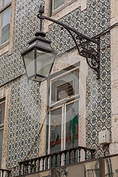 The old, metal, street lamps mounted on colorful tiled buildings in Lisbon, Portugal