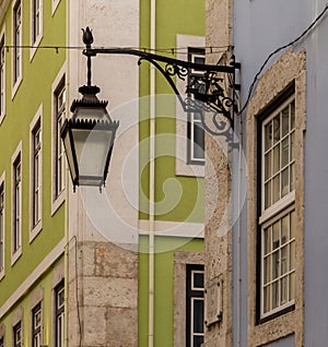 The old, metal, street lamps mounted on colorful tiled buildings in Lisbon, Portugal